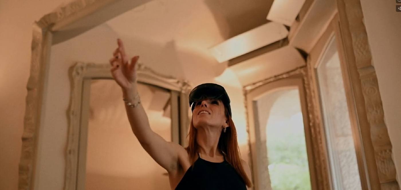Visitor reaching towards a hologram in a historic room